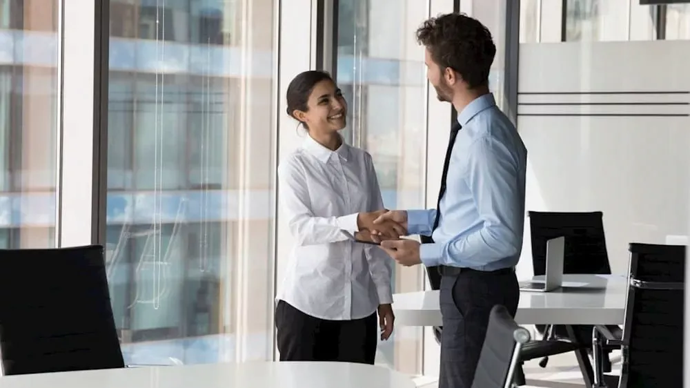 Two business executives shaking hands, symbolizing institutional trust and successful B2B fintech partnership in the European market.